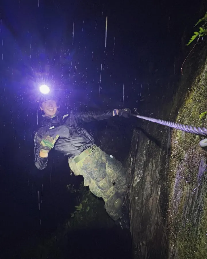 Tim Jambor climbing at night in the rain with a head torch